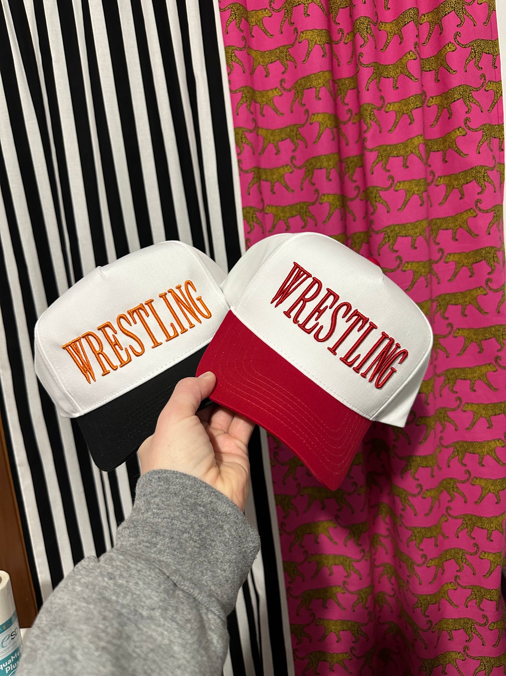 Two boxing gloves with 'Wrestling' text on a striped surface with a patterned background.